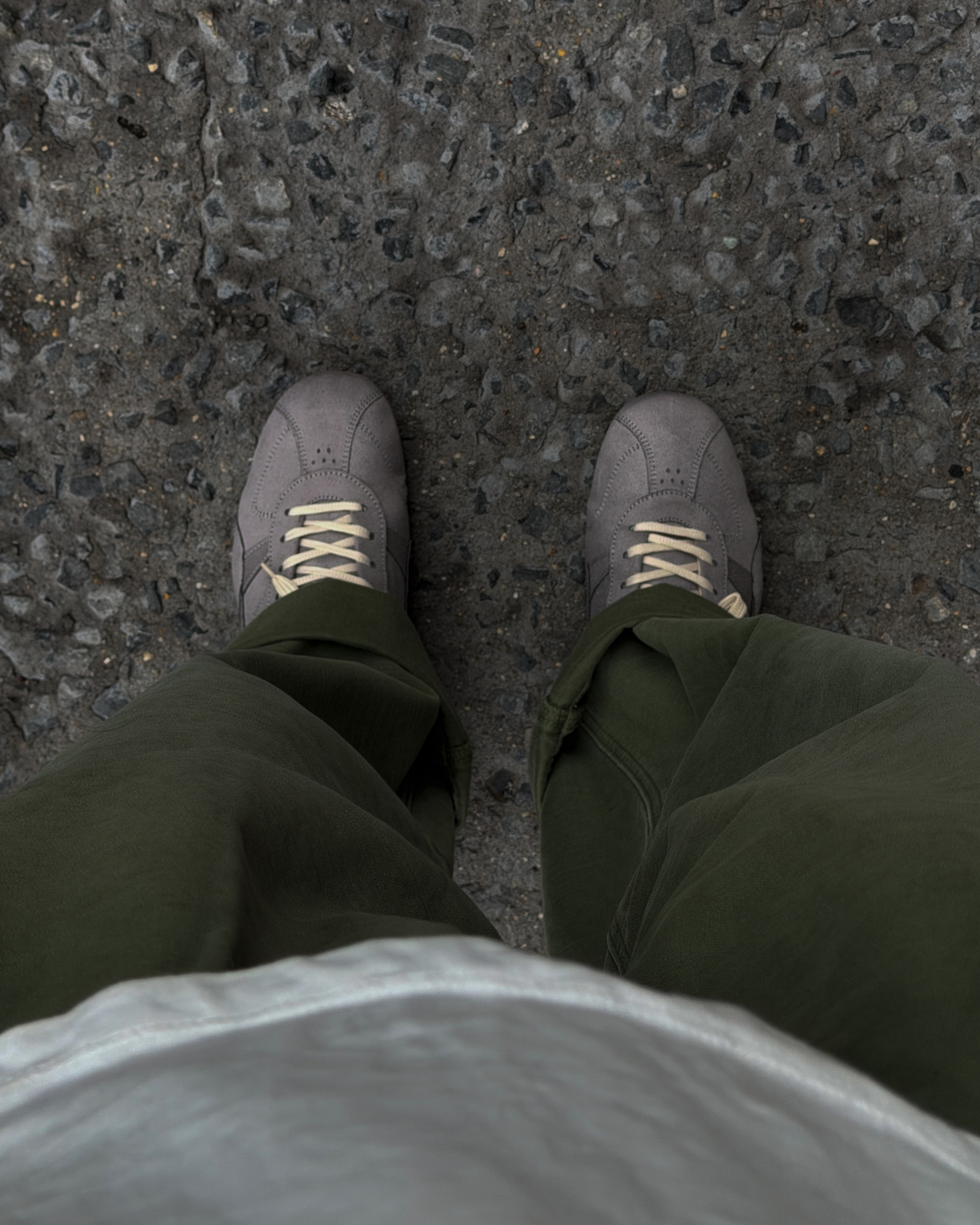 Grey sneakers styled with olive trousers