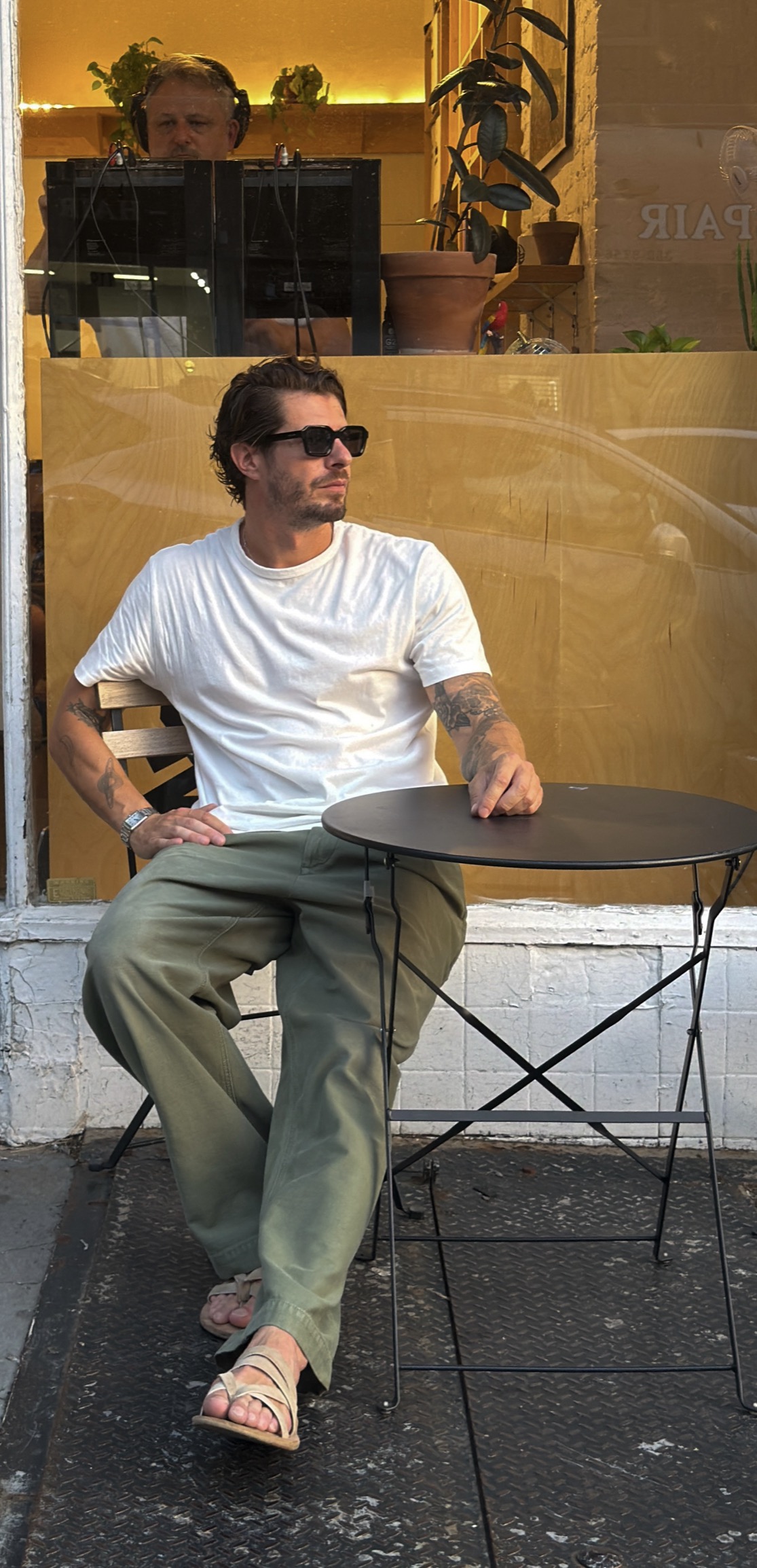 Kai Baker in a cream shirt and sunglasses